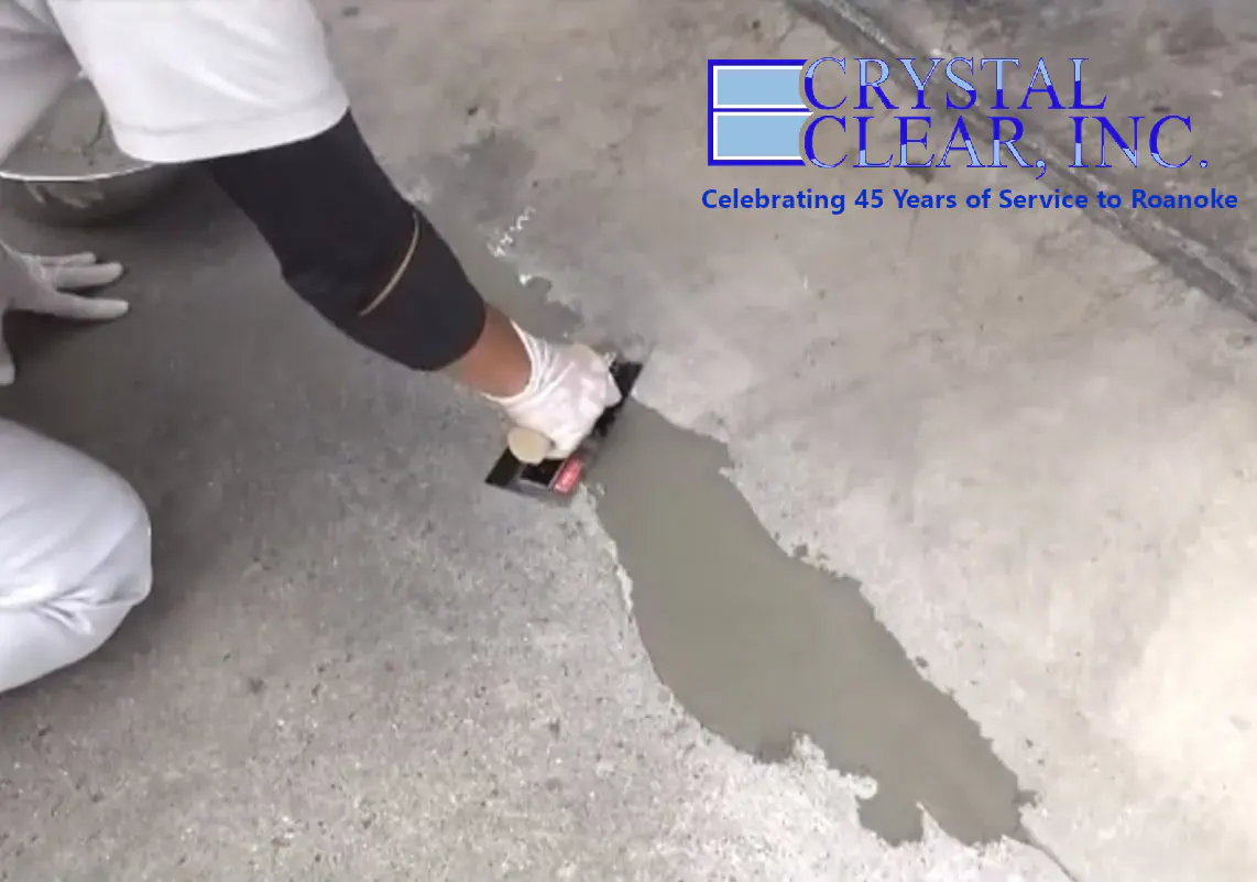 Image of a woman of color using a trowel to repair a concrete floor