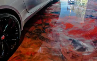 an image of a garage floor wit ha red and black mixed concrete epoxy basement floor, its shiny and striking in appearance