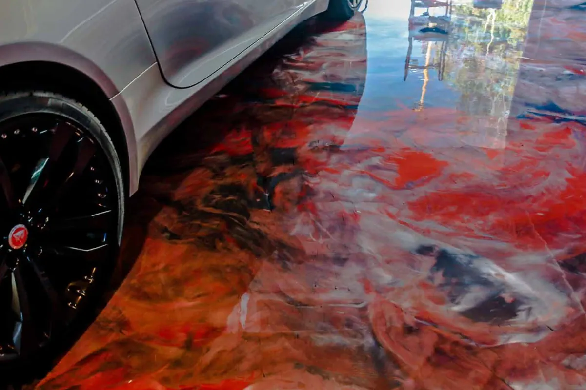 an image of a garage floor wit ha red and black mixed concrete epoxy basement floor, its shiny and striking in appearance