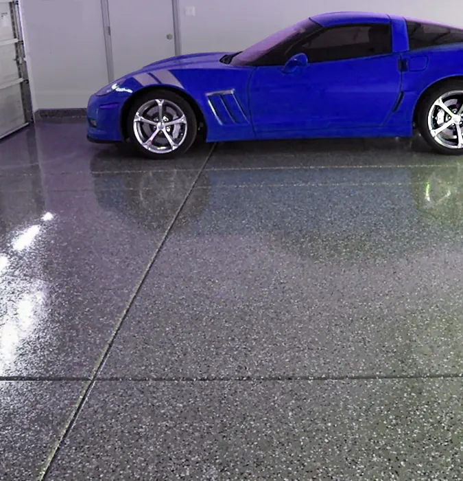 an image of a late model corvet on a epoxy coated garage floor, the colors of the floor are lightest blue, white and grey flecks it looks awesome!