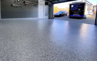 an image of a Epoxy Finish Garage Floor, brand new installation and it's a speckled finish of grey and white, it looks shiny and its a great look for a garage floor