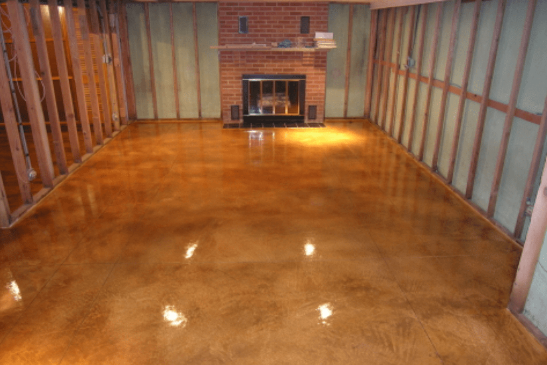 an image of a basement being finished, the floor is already done and its a stunning wood pattern of many shades of yellow and brown, its very shiny and looks awesome