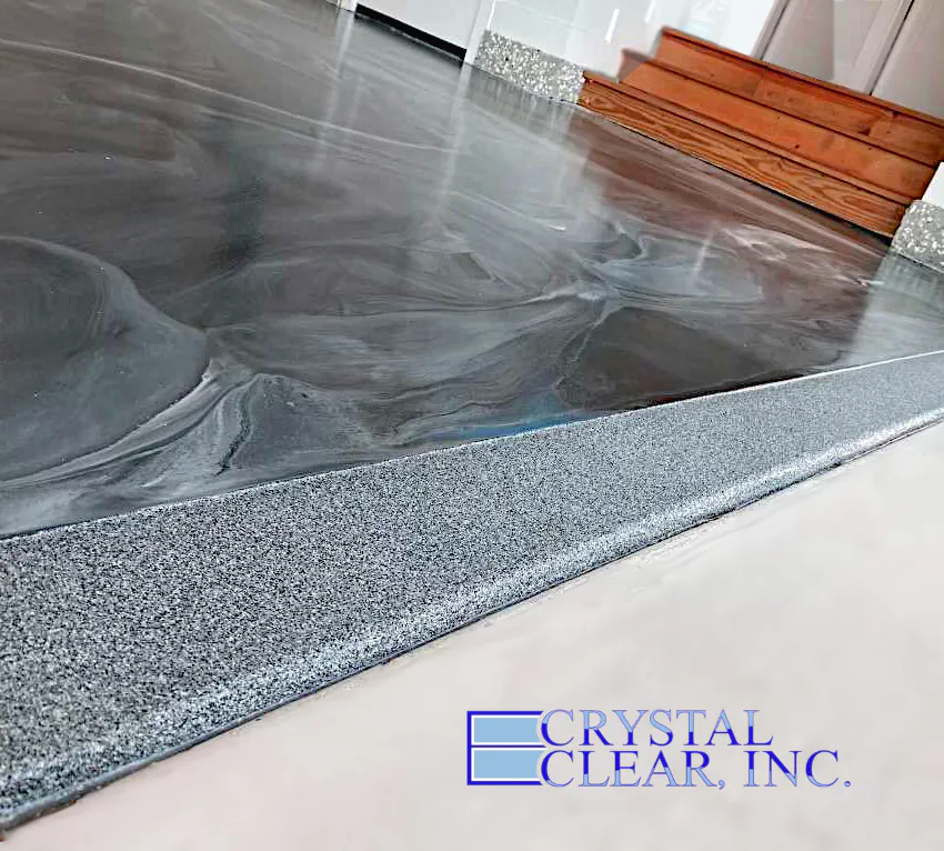 an image of a newly installed Epoxy Finish Garage Floor and it looks like drark grey almost black marble slabs wit ha same colors but this time speckled concrete skirt around the whole garage, very cool.